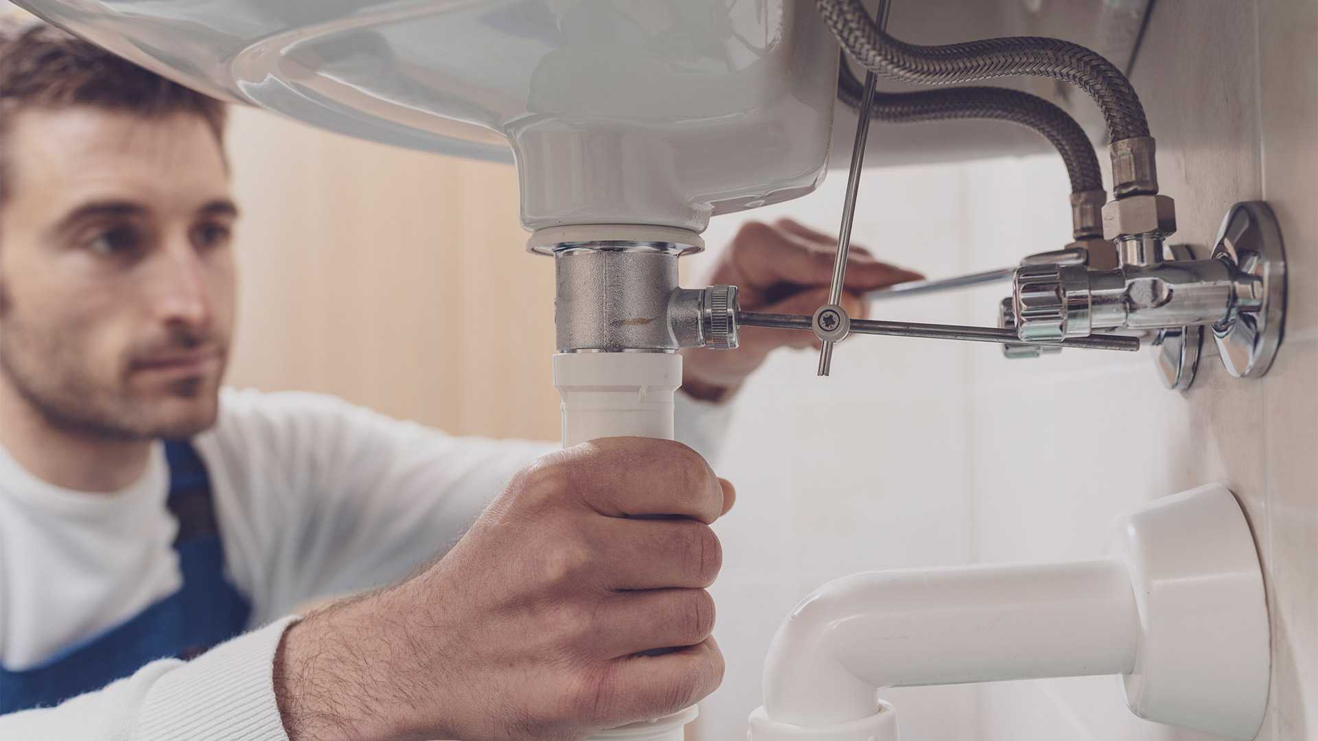 plumber fixing a sink at home